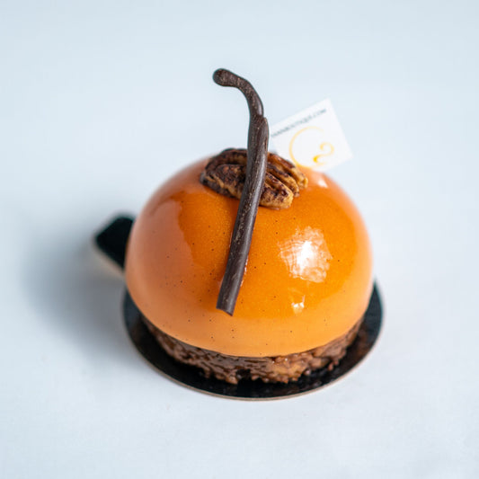 Delicate dessert with orange glaze and chocolate elements on a light background