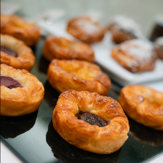 Originally a specialty from Britany, Yann's Kouign-Amman brings you a version sure to please! Designed not to be too sweet, this caramelized croissant dough hugs a heart of blackcurrant and apple A little more of France