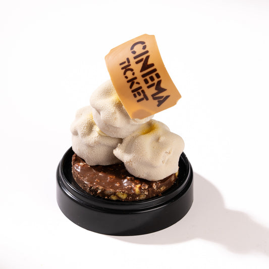 chocolate popcorn with a cinema ticket on top against a white background