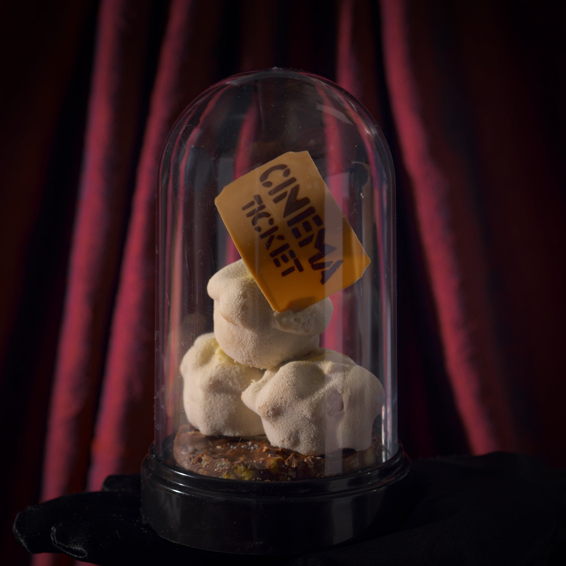 Popcorn-inspired Father's Day dessert from Yann Haute Patisserie featuring popcorn crunch, cashew base, corn chocolate blondie, corn chocolate praline, and chocolate ganache topped with popcorn kernels and a movie ticket.