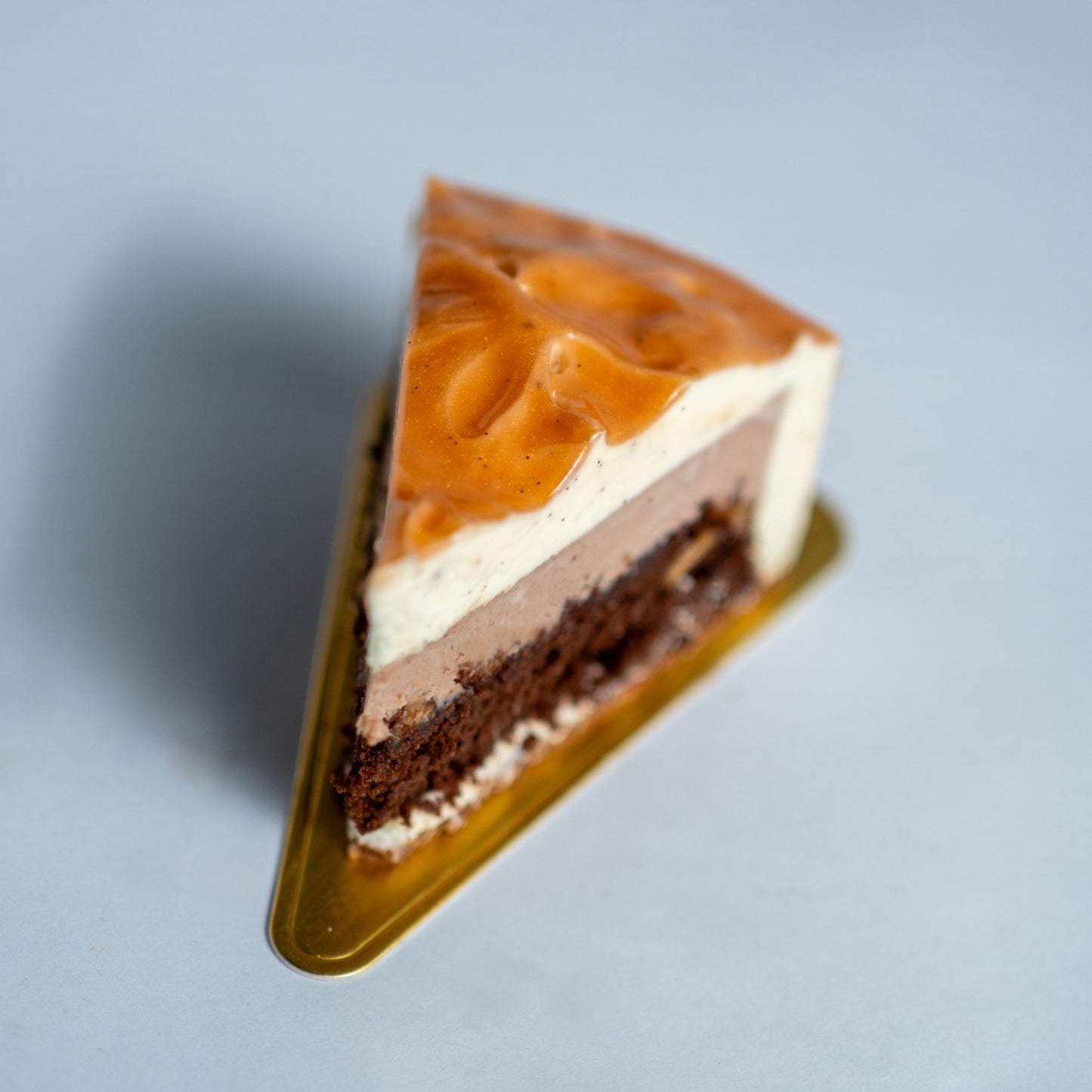 Triangular slice of layered cake on a gray background