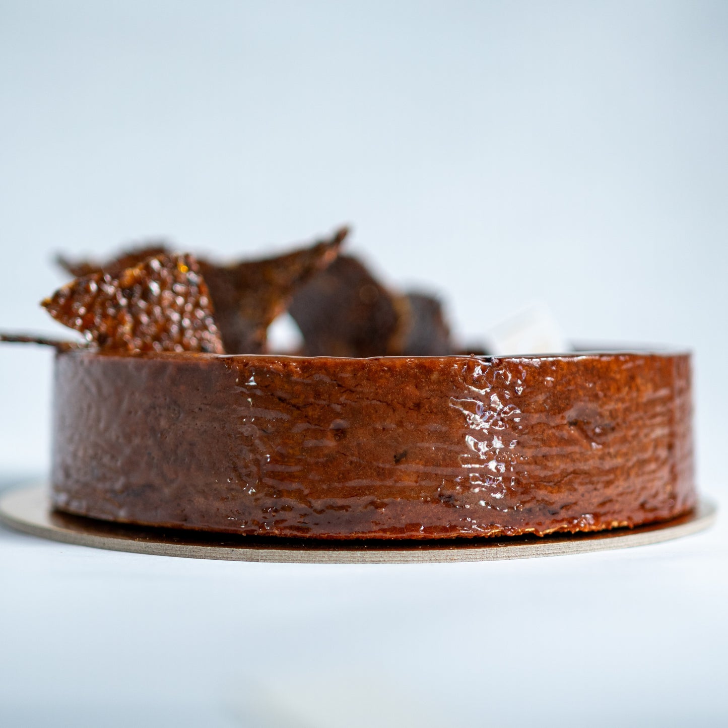 Chocolate cake flan with a decorative nougatine top on a light background
