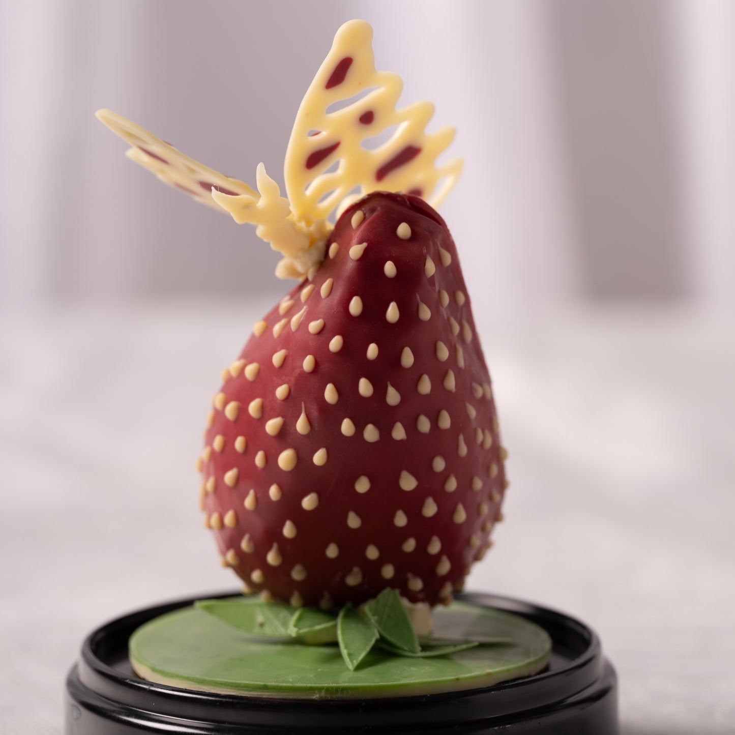 Chocolate butterfly decoration on strawberry dessert, coconut praline and chocolate pastry Calgary, handcrafted Easter treat by Yann Haute Patisserie, premium bakery YYC, artistic dessert presentation