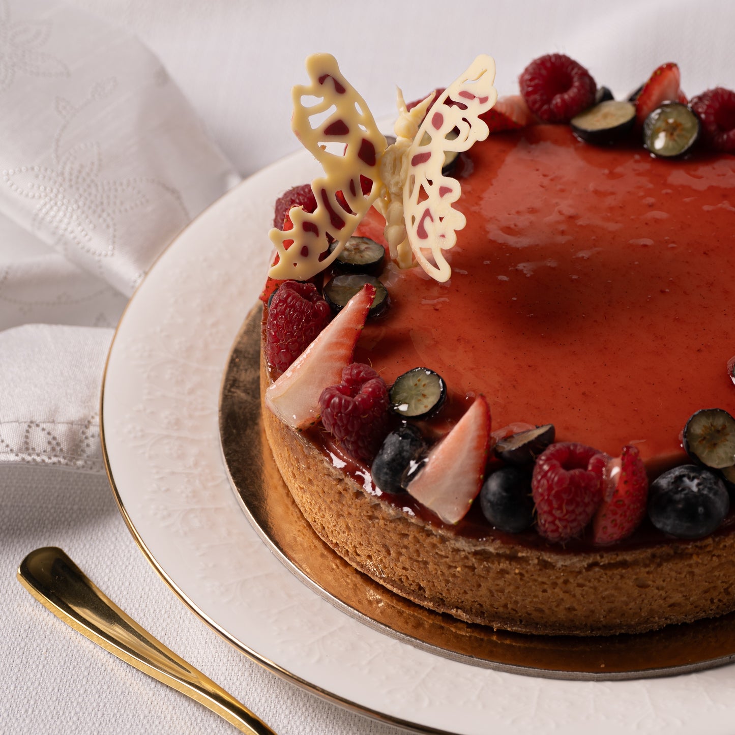 Close-up of raspberry coconut tart layers, almond frangipane base with smooth coconut crème brûlée and fresh berries, handcrafted Mother’s Day dessert Calgary, premium French bakery YYC, gourmet pastry texture