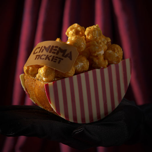 Father's Day croissant filled with caramel sauce, topped with caramel popcorn, and finished with striped white and raspberry chocolate.