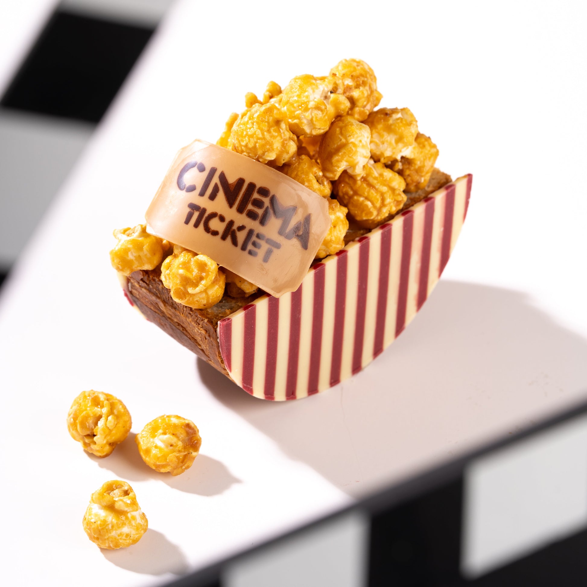 Caramel Popcorn on a croissant with striped chocolate with a cinema ticket label on a white background