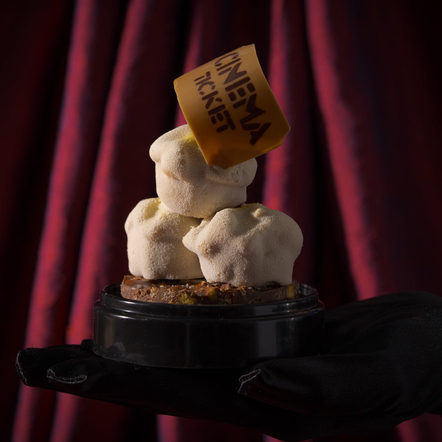 Limited-edition Father's Day cake inspired by movie-night popcorn, decorated with three popcorn kernels and a movie ticket, layered with chocolate, corn, and crunchy textures.