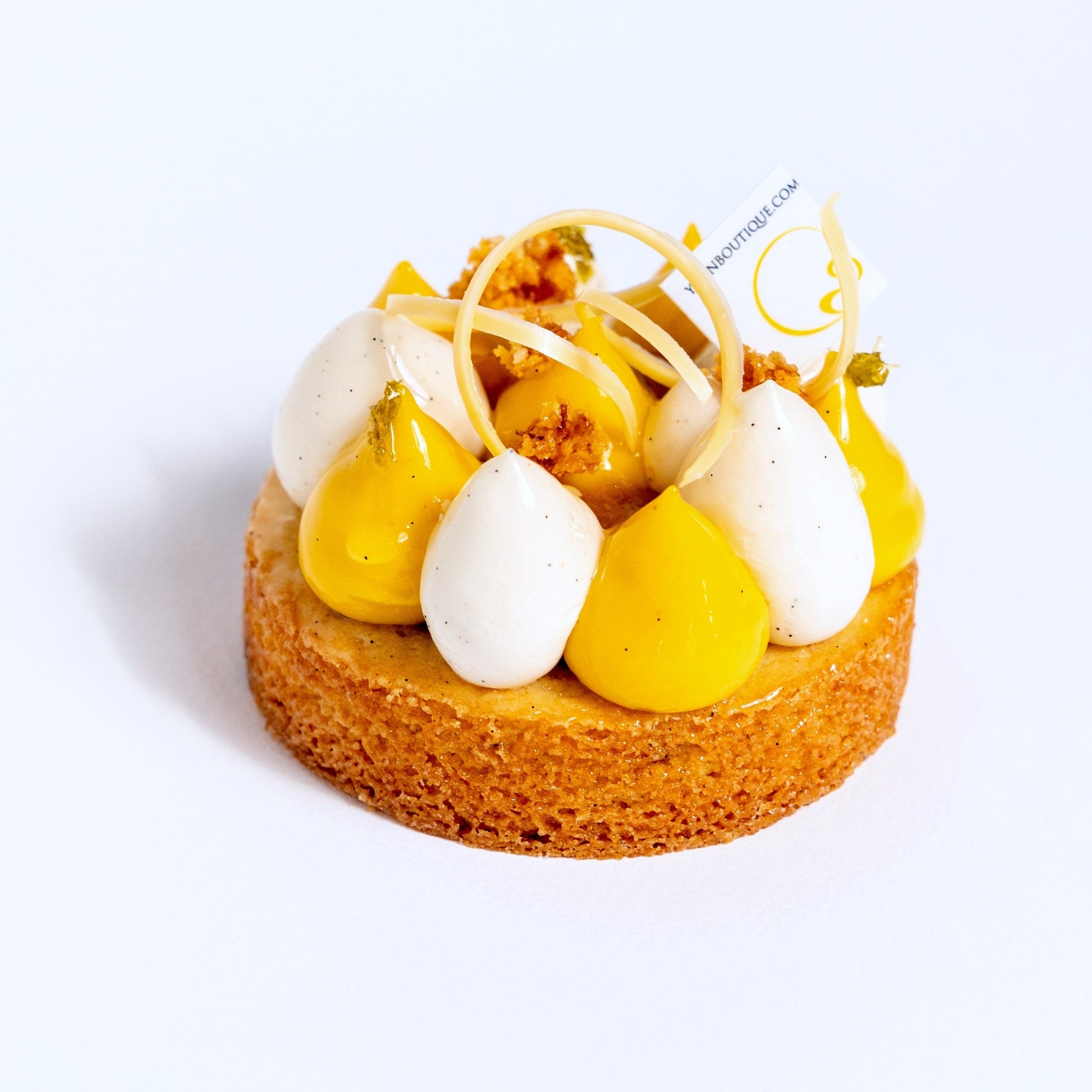 Sable Breton base, white chocolate &amp; coconut crunch, passion fruit compote, white chocolate &amp; vanilla bean chantilly, mango cremeux, coconut nougatine, candied lime zests, passion fruit chocolate swirls.