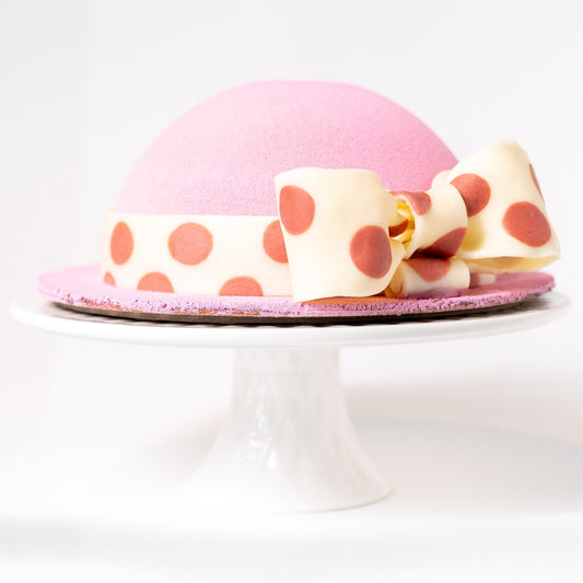 What an Elegante large cake hat! Celebrate all the mother figures in your life with this unique creation, limited quantities Description: Yogurt yuzu mousse, vanilla/lime cremeux, almond biscuit (joconde), Chefs' strawberry compote (melon /lime), sachertorte, red fruit (crunch) feuilletine on a cookie base!