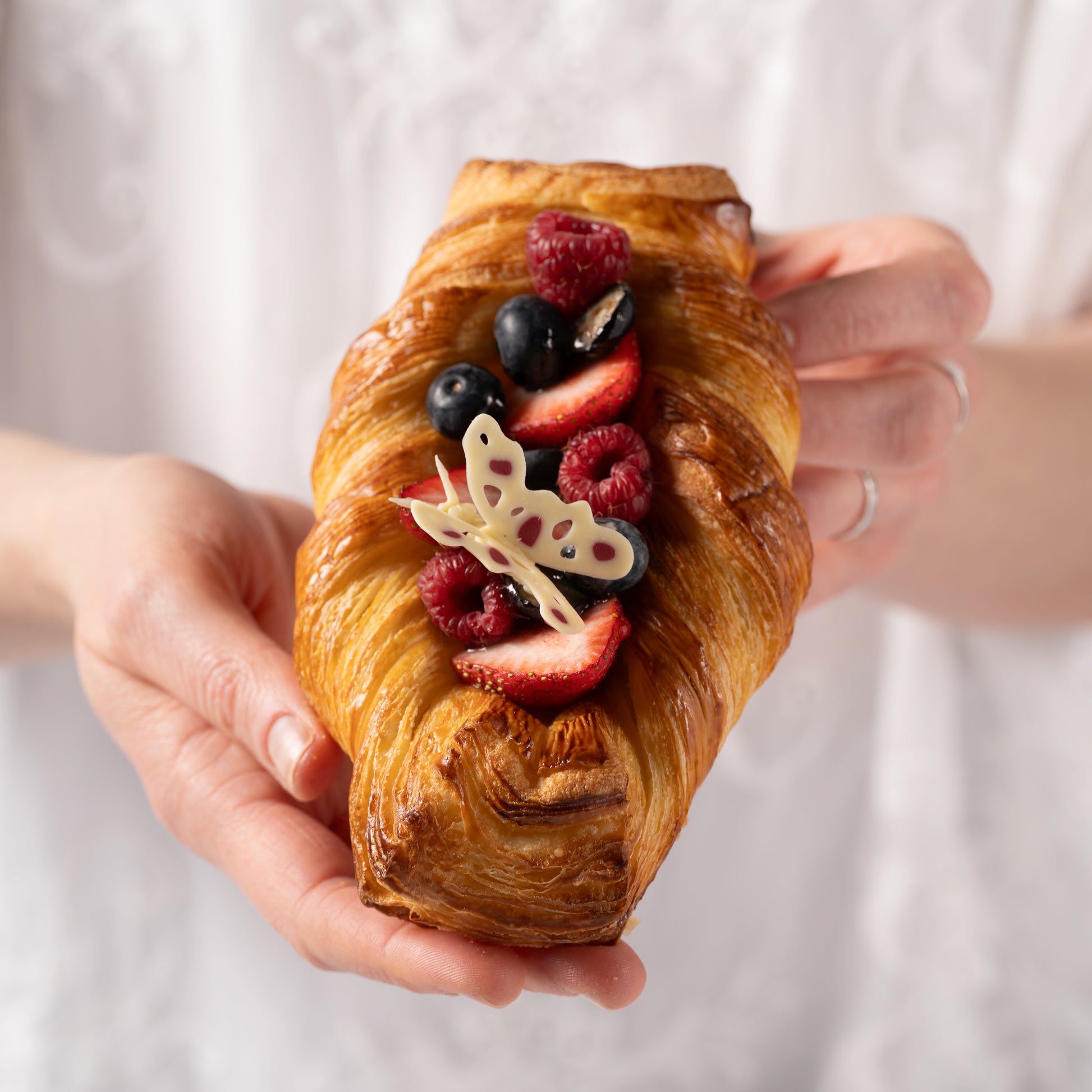 Croissant with seasonal fruits Calgary, handcrafted French pastry by Yann Haute Patisserie, buttery croissant dough with shortbread base filled with pastry cream, fresh strawberries and blueberries, Easter dessert Calgary, luxury bakery YYC, artisan fruit croissant