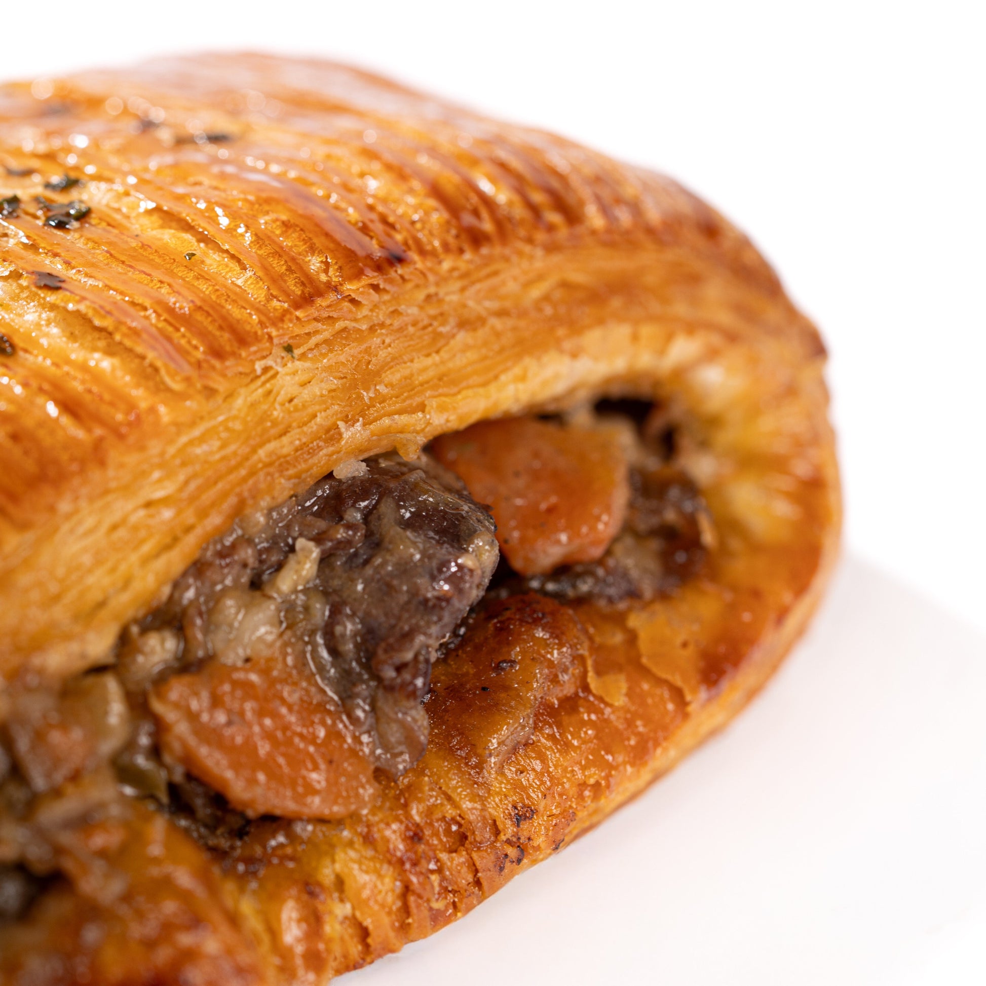 Flaky Pain Suisse croissant filled with classic French boeuf bourguignon, carrots and potatoes from Calgary's French pastry shop.