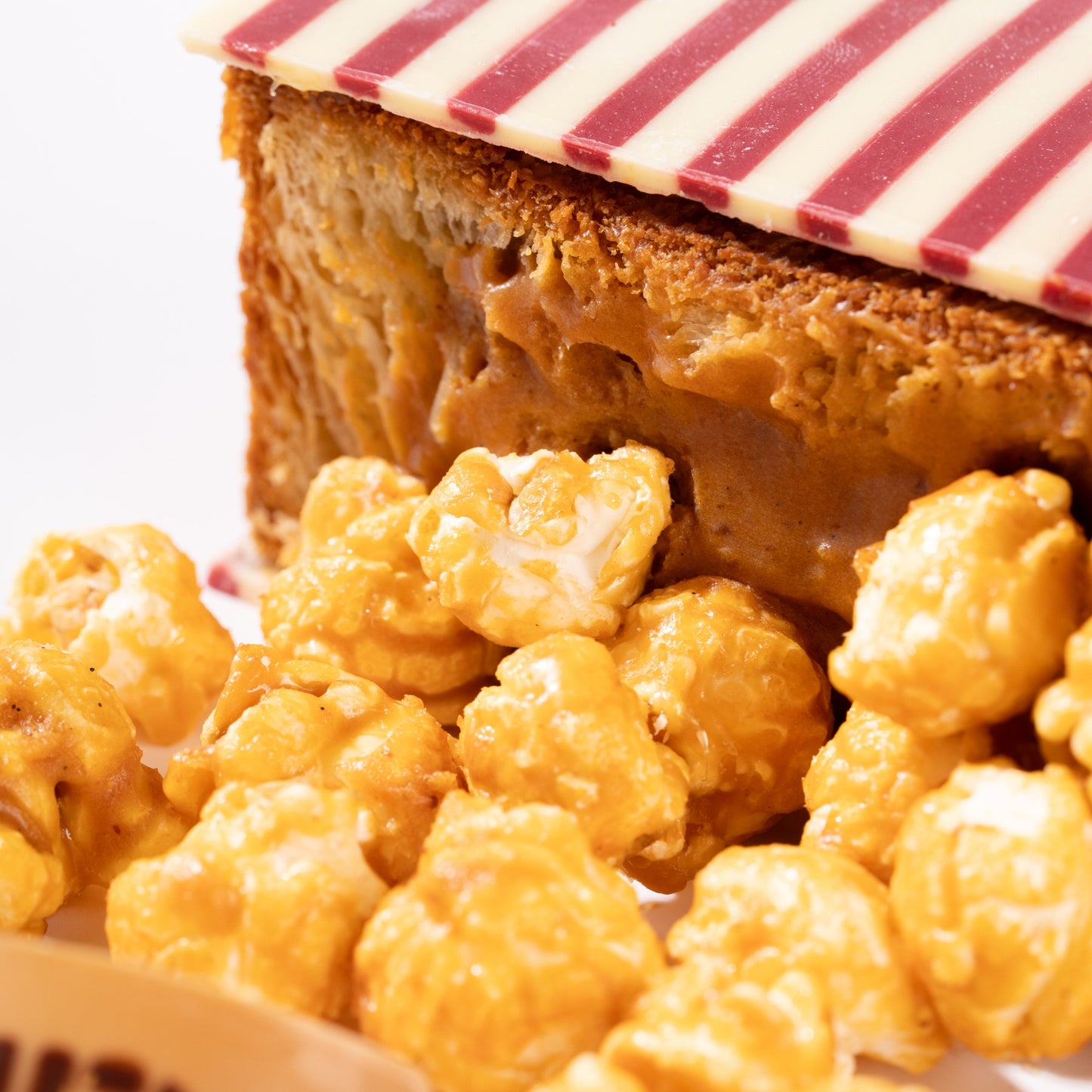 Close-up of a croissant with caramel popcorn and a striped lid