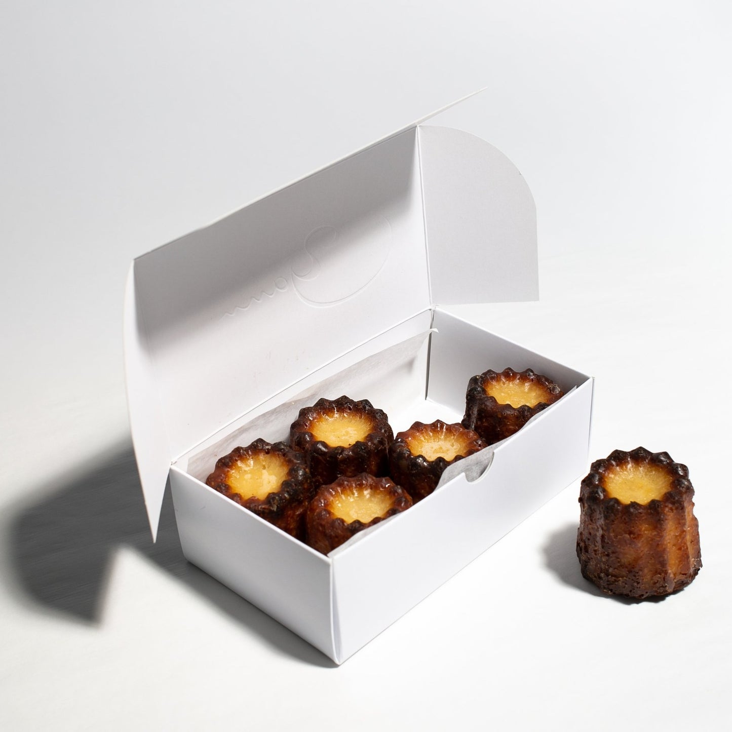 Canneles de Bordeaux, vanilla and rum for a unique little treat! Yann Haute Patisserie, French desserts and bakery shop in Calgary. Best pastries like macarons, cakes, birthday cakes, bread, ice cream and almond croissants!